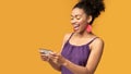 Afro woman using mobile phone playing games at studio Royalty Free Stock Photo
