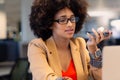 Afro young african american businesswoman talking through smartphone speaker using laptop at office Royalty Free Stock Photo