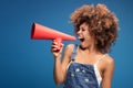 Afro young girl screaming by red megaphone.