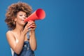 Afro young girl screaming by red megaphone. Royalty Free Stock Photo