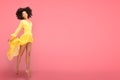 Afro girl dancing in yellow maxi dress