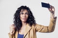 Afroamerican black woman making selfie photo. Black long hair, leather jacket