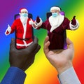 Afroamerican and caucasian-white hands holding phones with 2 Santa Clauses.