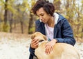 Afroamerican girl in autumn park playing with her dog Royalty Free Stock Photo