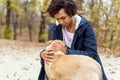 Afroamerican girl in autumn park playing with her dog Royalty Free Stock Photo