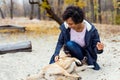 Afroamerican girl in autumn park playing with her dog Royalty Free Stock Photo