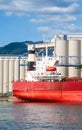 Aft end of dry-cargo ship moored at marine terminal for loading. Royalty Free Stock Photo