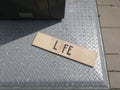 Afterlife, sign with one letter missing laying on the ground near the trashbin