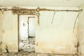 Aftermath abandoned and destroyed house interior with damaged walls and broken doors full of bricks and plaster parts fallen after