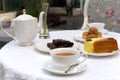 Afternoon tea with cup of tea and teapot on table with cake