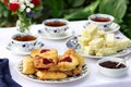 Afternoon tea in the garden with scones, strawberry jam, finger sandwiches with cucumber and egg salad. Royalty Free Stock Photo