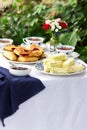 Afternoon tea in the garden with scones, strawberry jam, finger sandwiches with cucumber and egg salad.