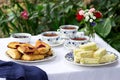 Afternoon tea in the garden with scones, strawberry jam, finger sandwiches with cucumber and egg salad.