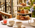 Afternoon tea in the restaurant garden, English tradition and luxury service, tea cups, cakes, scones, sanwiches and desserts, Royalty Free Stock Photo