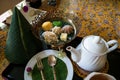 Afternoon tea time set of Thai traditional dessert with fine banana leaf and flower decoration on floral pattern table cloth Royalty Free Stock Photo