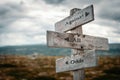 Against all odds text on wooden rustic signpost outdoors in nature/mountain scenery. Royalty Free Stock Photo