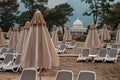 Against the backdrop of the famous structure sun loungers and folded beach umbrellas on the beach