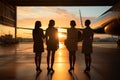 Against a backdrop of a passenger aircraft, four lovely stewardesses stand in hangar sunset