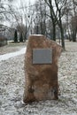 Against the backdrop of a winter park park, a blurred image of a stone with a sign for writing text