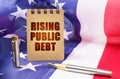 Against the background of the American flag is a notepad with the inscription - rising public debt