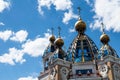 Against the background of a blue sky with clouds, a fragment of church domes