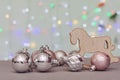 Against the background of bokeh of Christmas lights, Christmas balls and a Christmas tree toy - a wooden rocking horse. Concept - Royalty Free Stock Photo