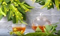 Teapot and cup with linden tea and flowers on a wooden table against a brick wall background Royalty Free Stock Photo