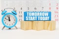 Against the background of the calendar, an alarm clock and a blue block with the inscription - Tomorrow Start Today Royalty Free Stock Photo