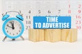 Against the background of the calendar is an alarm clock, cubes and a blue block with the inscription -Time to Advertise