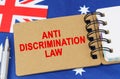 Against the background of the flag of Australia lies a notebook with the inscription - ANTI DISCRIMINATION LAW