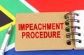 Against the background of the flag of South Africa lies a notebook with the inscription - IMPEACHMENT PROCEDURE