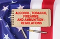 Against the background of the flag of the USA lies a notebook with the inscription -ALCOHOL, TOBACCO, FIREARMS