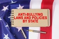 Against the background of the flag of the USA lies a notebook with the inscription - ANTI BULLYING LAWS
