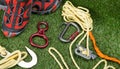 Against the background of a green lawn, lies a set of items for the expedition, a climbing rope and shoes for traveling