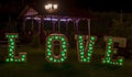 Close. Against the background of a lantern, photo area. Wedding decor. Large white letters, with green lights, with the inscriptio