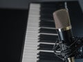 Against the background of a midi keyboard, a synthesizer is a professional studio microphone. Recording studio, concert, Royalty Free Stock Photo