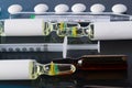 Against the background of a photograph of a person with suspected coronavirus, a syringe with a drug, ampoules and a thermometer