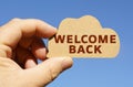 Against the background of the sky in the hands of a man, a figure of a cloud with the inscription - welcome back Royalty Free Stock Photo