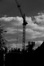Against the background of trees and sky, a construction crane from a construction site is visible. Royalty Free Stock Photo