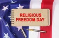 Against the background of the US flag lies cardboard with the inscription - RELIGIOUS FREEDOM DAY