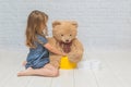 Against the background of a white brick wall, the girl sits on a Royalty Free Stock Photo