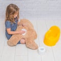 Against the background of a white brick wall, the girl sits on a Royalty Free Stock Photo