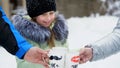 against the background of winter forest, a girl of seven years drinks tea from a cup, on the cups, sponges are drawn Royalty Free Stock Photo