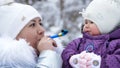 against the background of the winter forest, a young woman, Mom holds on her hands and amuses a one-year-old daughter Royalty Free Stock Photo