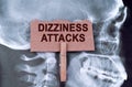 Against the background of an X-ray of the skull, a plate with the inscription - Dizziness attacks Royalty Free Stock Photo
