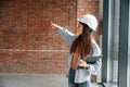 Against brick wall. Young woman is standing in the unfinished building on construction site and working on a project Royalty Free Stock Photo