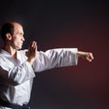 Against a dark red background, a young athlete makes a punch arm