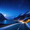 Against the sea at the foot of the mountains at night the road trailing car tail lights under a beautiful starry