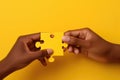 Against a vibrant yellow background, two hands complete a puzzle piece