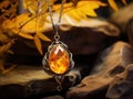 Amber Allure: Delicate Pendant on a Chain Amidst Dried Leaves on a Sandstone Canvas